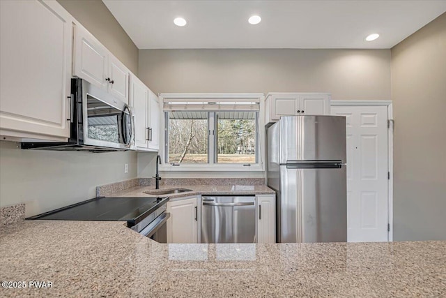 134 Laurel Hill Dr Unit 102, Greentown, PA 18426 - kitchen with a sink, appliances with stainless steel finishes, recessed lighting, white cabinetry, and light stone counters
