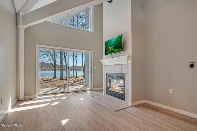 134 Laurel Hill Dr Unit 102, Greentown, PA 18426 - unfurnished living room featuring wood finished floors, high vaulted ceiling, a fireplace, and a wealth of natural light
