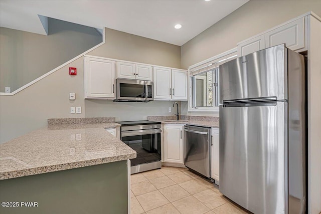134 Laurel Hill Dr Unit 102, Greentown, PA 18426 - kitchen featuring a peninsula, white cabinets, light tile patterned flooring, a sink, and stainless steel appliances