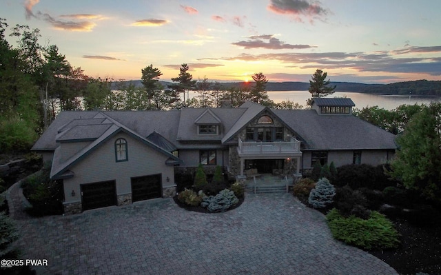 130 Calico Ct, Paupack, PA 18451 - view of front of home with a water view, decorative driveway, a balcony, stone siding, and an attached garage