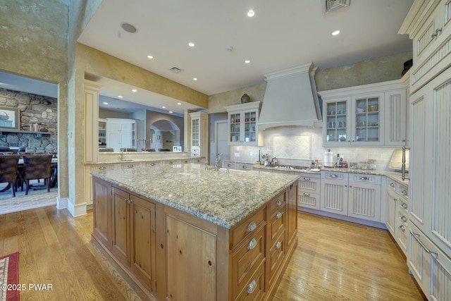 130 Calico Ct, Paupack, PA 18451 - kitchen featuring a center island with sink, light wood-style floors, custom range hood, and a sink