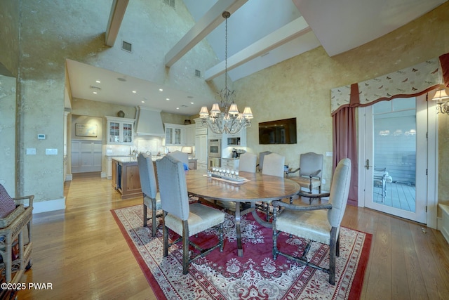 130 Calico Ct, Paupack, PA 18451 - dining area with an inviting chandelier, light wood-style flooring, visible vents, and a high ceiling