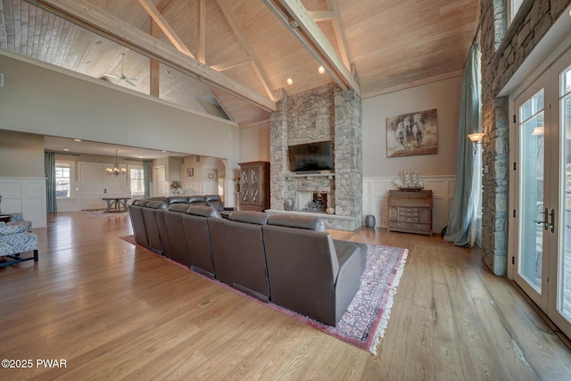 130 Calico Ct, Paupack, PA 18451 - living area with a stone fireplace, wooden ceiling, an inviting chandelier, wood finished floors, and a decorative wall