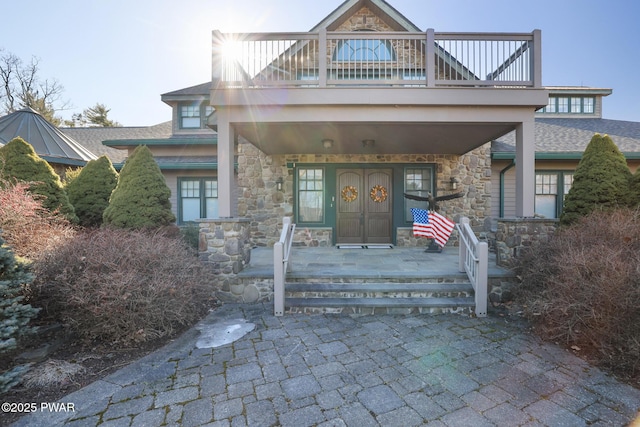 130 Calico Ct, Paupack, PA 18451 - view of front of property with a balcony, covered porch, stone siding, and a shingled roof