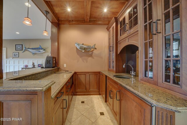 130 Calico Ct, Paupack, PA 18451 - kitchen with a sink, a wainscoted wall, brown cabinets, and light stone counters