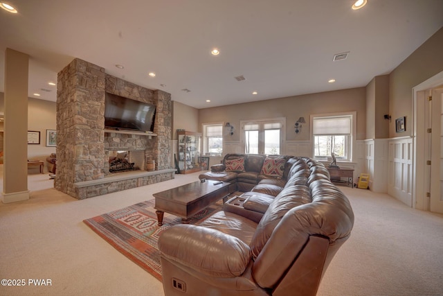 130 Calico Ct, Paupack, PA 18451 - living area with visible vents, carpet, a stone fireplace, and wainscoting