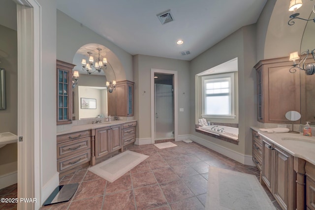 130 Calico Ct, Paupack, PA 18451 - bathroom with visible vents, two vanities, a sink, a bath, and a chandelier