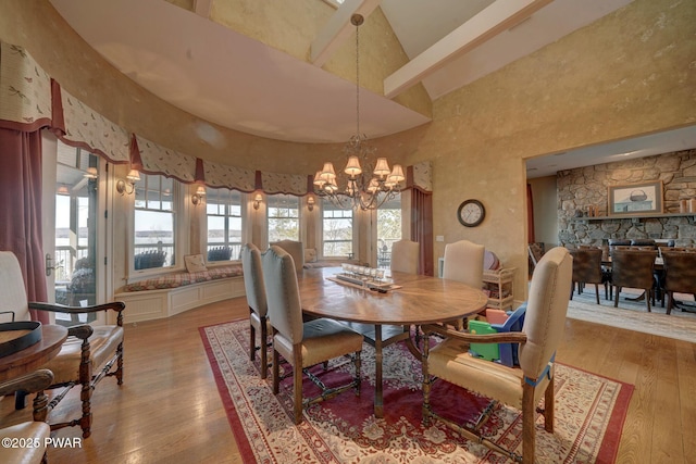 130 Calico Ct, Paupack, PA 18451 - dining space featuring light wood-style flooring, a high ceiling, and an inviting chandelier