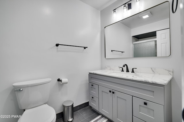 full bath with tile patterned flooring, toilet, vanity, baseboards, and a stall shower