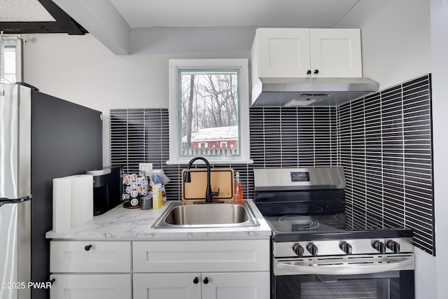 kitchen featuring tasteful backsplash, appliances with stainless steel finishes, under cabinet range hood, white cabinetry, and a sink