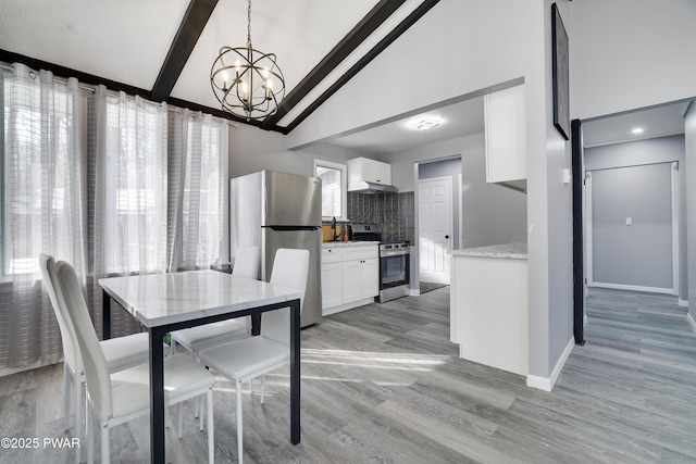 dining room with light wood finished floors, baseboards, a chandelier, high vaulted ceiling, and beam ceiling