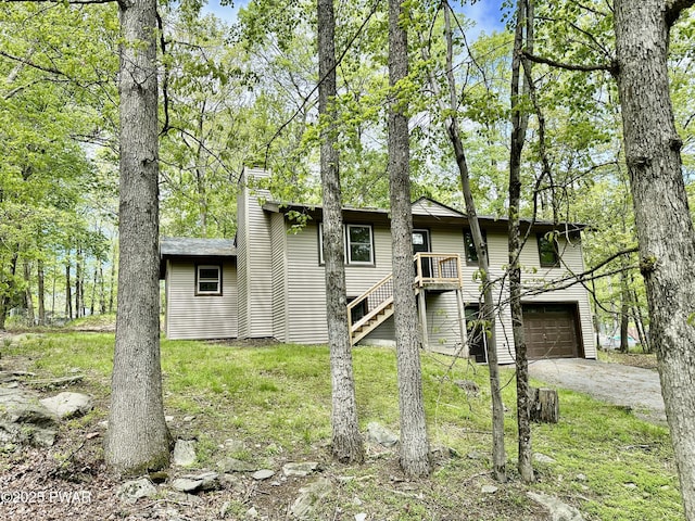 106 Rodeo Ln, Lords Valley, PA 18428 - view of front of house with driveway, a garage, a chimney, and stairs