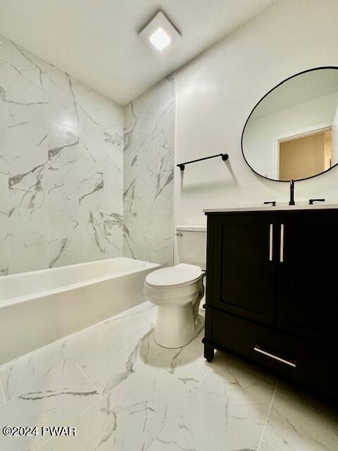 full bathroom with vanity, tiled shower / bath combo, and toilet