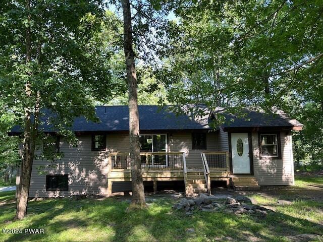 view of front of home with a deck and a front yard