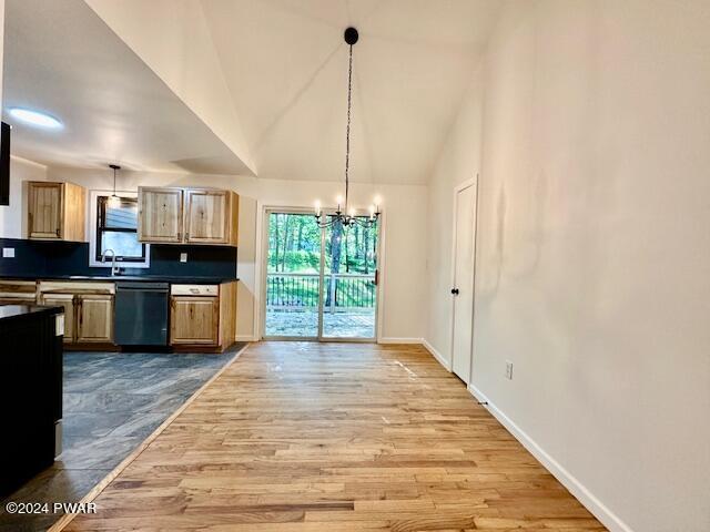 kitchen featuring hanging light fixtures, black dishwasher, tasteful backsplash, light hardwood / wood-style flooring, and a notable chandelier