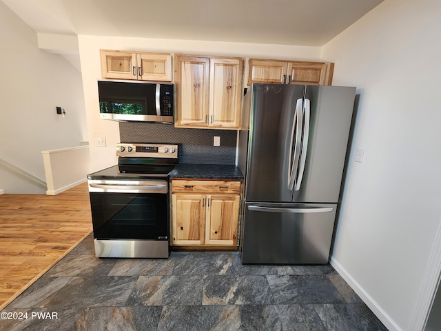 106 Rodeo Ln, Lords Valley, PA 18428 - kitchen with appliances with stainless steel finishes, light brown cabinetry, dark stone finish floors, and dark countertops