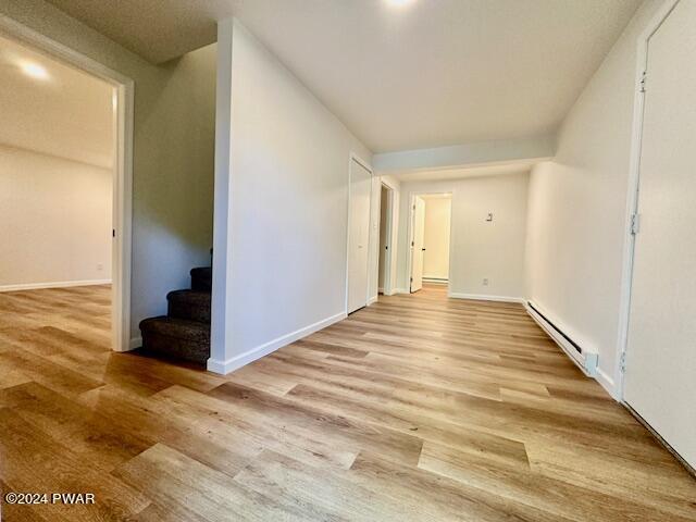 interior space with light hardwood / wood-style floors and a baseboard heating unit