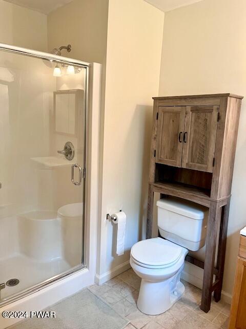 bathroom featuring vanity, toilet, and a shower with door