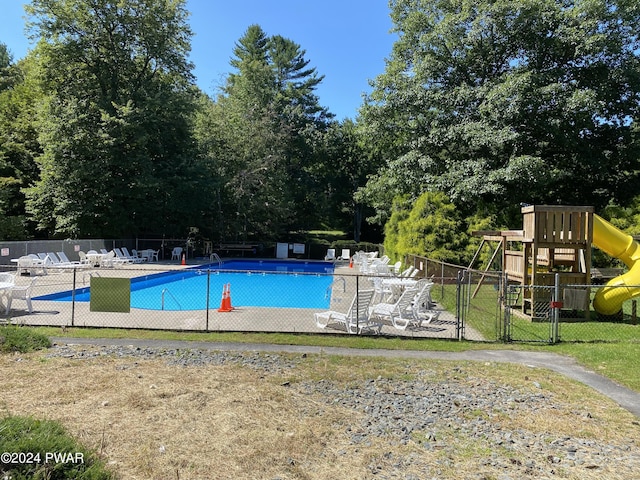 view of pool featuring a playground and a patio area