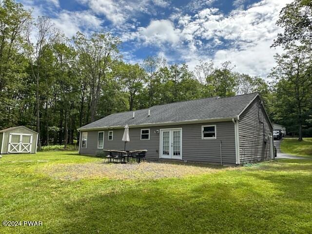 rear view of property featuring a lawn and french doors