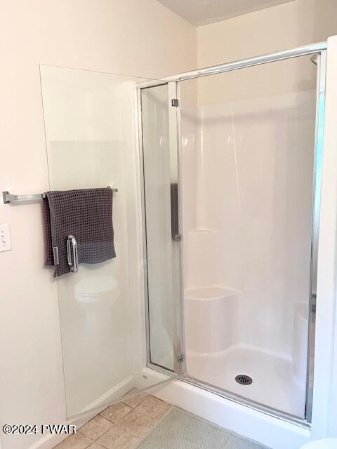 bathroom featuring tile patterned floors and a shower with door