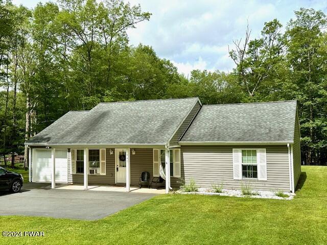 view of front of home with a porch, a garage, and a front lawn