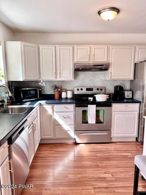 kitchen featuring light hardwood / wood-style flooring, white cabinets, stainless steel appliances, and sink