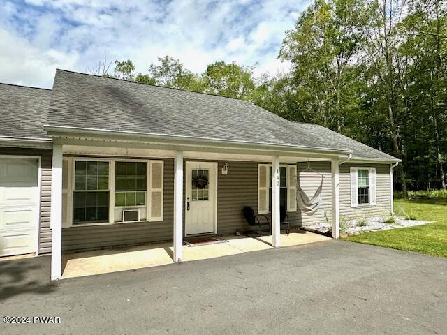 view of front of property with a porch, a garage, and a front yard