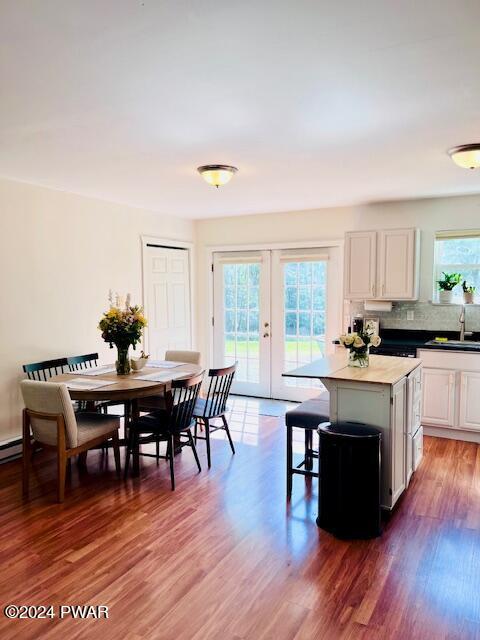 kitchen with white cabinets, a kitchen island, wood-type flooring, and a wealth of natural light