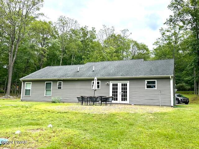 back of house featuring a lawn, french doors, and a patio