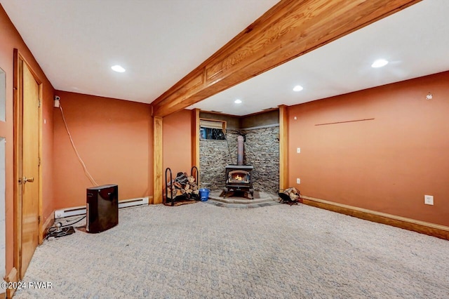 carpeted living room with a wood stove and a baseboard heating unit