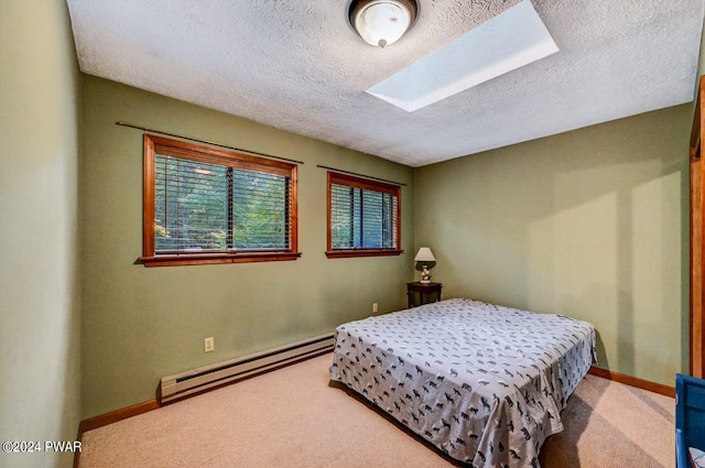 bedroom with light carpet, a textured ceiling, and a baseboard heating unit