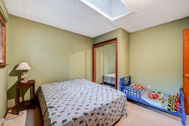 bedroom with carpet flooring, a textured ceiling, and a closet