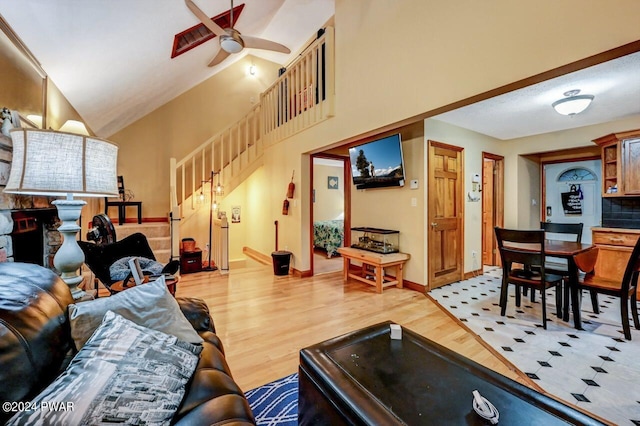 living room featuring ceiling fan, hardwood / wood-style floors, and lofted ceiling