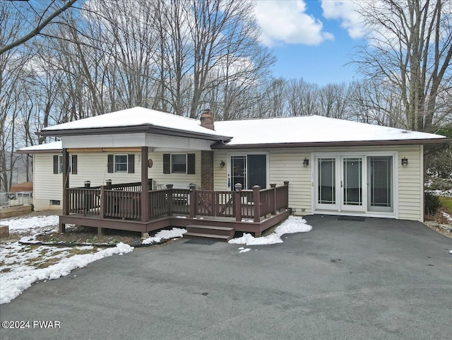 snow covered house with a wooden deck