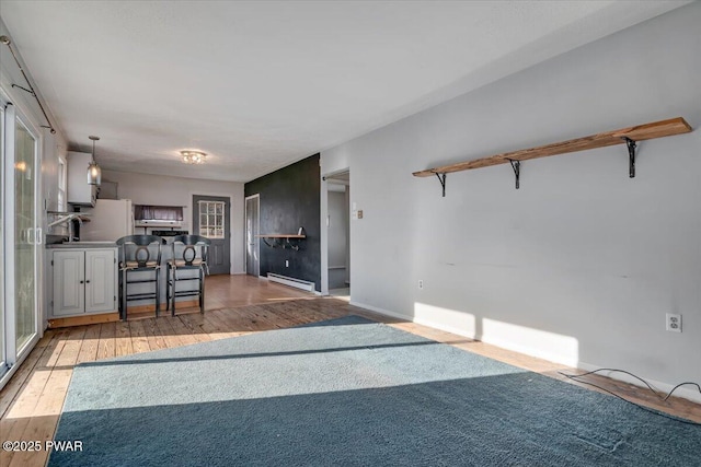 living area featuring light wood-type flooring and baseboard heating