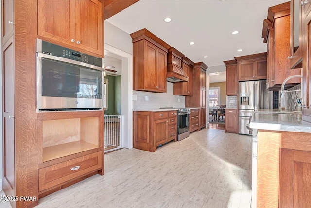 kitchen featuring recessed lighting, light countertops, stainless steel appliances, and custom exhaust hood