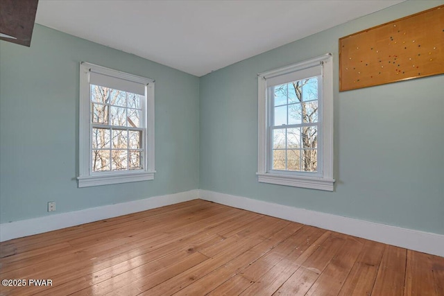 empty room with baseboards and light wood-style floors