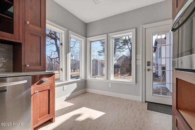 interior space with baseboards, a wealth of natural light, and light wood-style floors