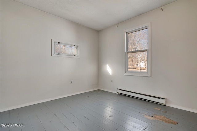 empty room with baseboards, a baseboard radiator, and wood-type flooring