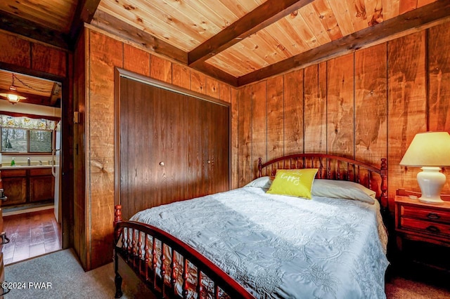 bedroom featuring wood walls, carpet floors, and sink