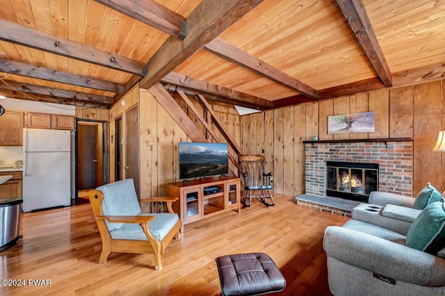 living room featuring wooden ceiling, wooden walls, light wood-type flooring, a fireplace, and beamed ceiling