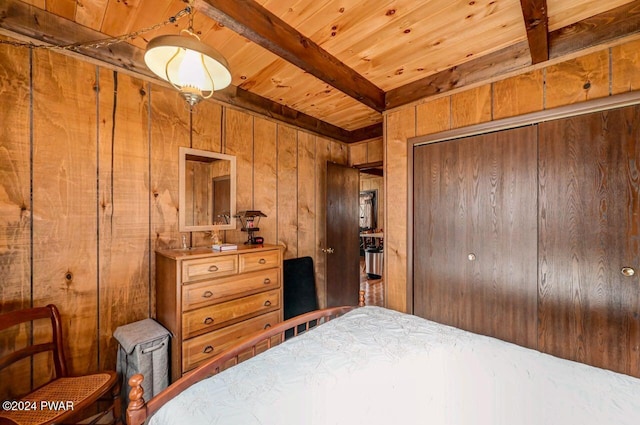 bedroom with beamed ceiling, wood walls, wooden ceiling, and a closet