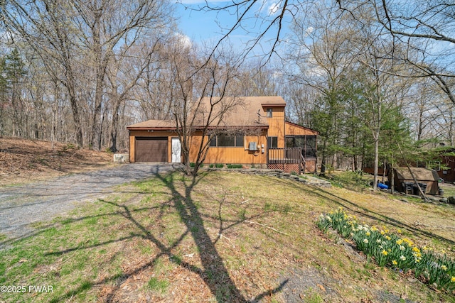 view of front of property featuring an attached garage and dirt driveway
