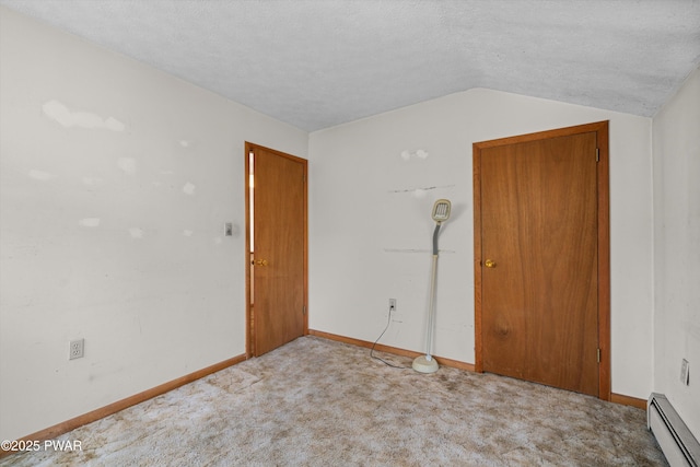 spare room with baseboards, a textured ceiling, a baseboard radiator, carpet, and vaulted ceiling