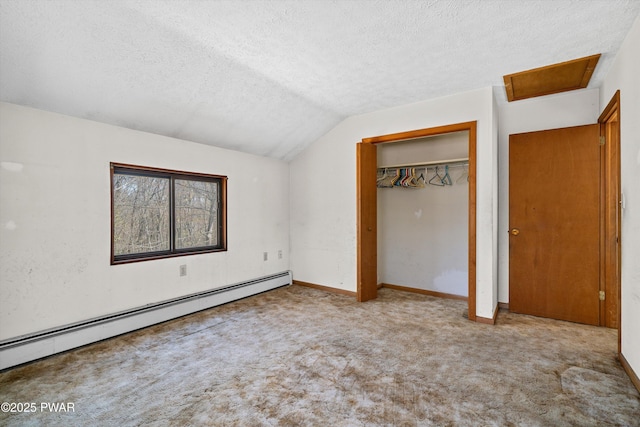 unfurnished bedroom with attic access, a textured ceiling, baseboard heating, carpet floors, and lofted ceiling