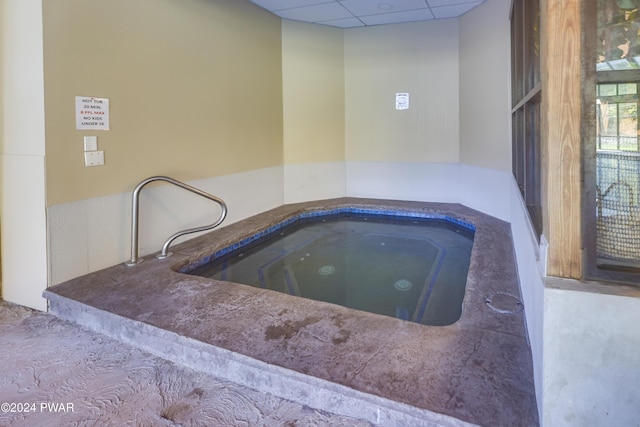 view of swimming pool with an indoor hot tub