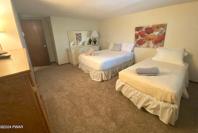 bedroom with a textured ceiling and carpet floors