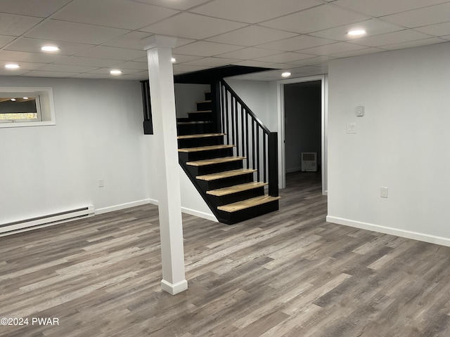 basement featuring baseboard heating and hardwood / wood-style floors