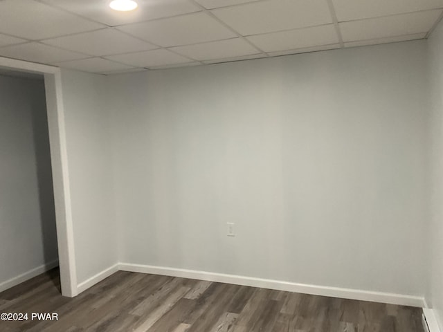 unfurnished room with a paneled ceiling, a baseboard radiator, and dark wood-type flooring